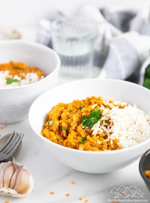 Two white bowls with sweet potato dhal