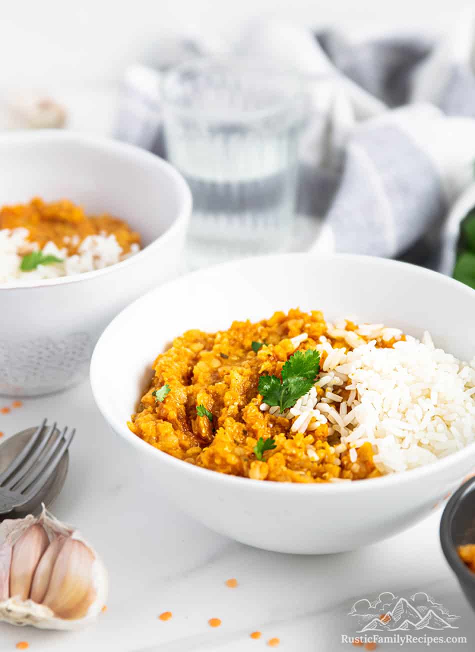 Two white bowls with sweet potato dhal