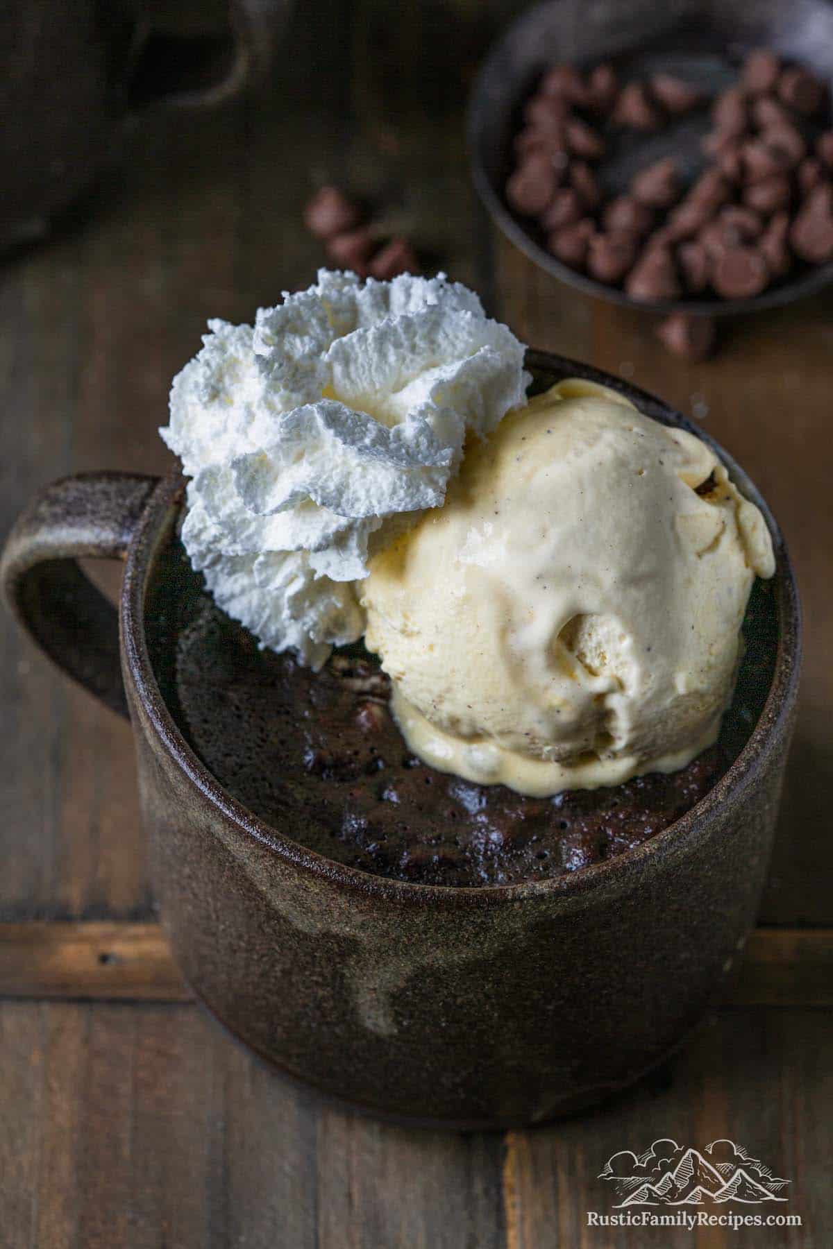 Brownie in a mug with ice cream and whipped cream