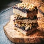 3 walnut blueberry shortbread cookie bars stacked on top of each other