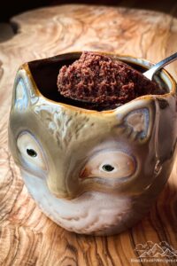 A brownie made in a fox shaped mug with a spoon scooping a bite out.