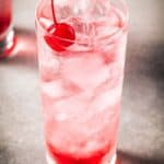 Shirley Temple drink in a tall glass with a cherry