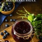 A jar on a wooden table with homemade blueberry sauce