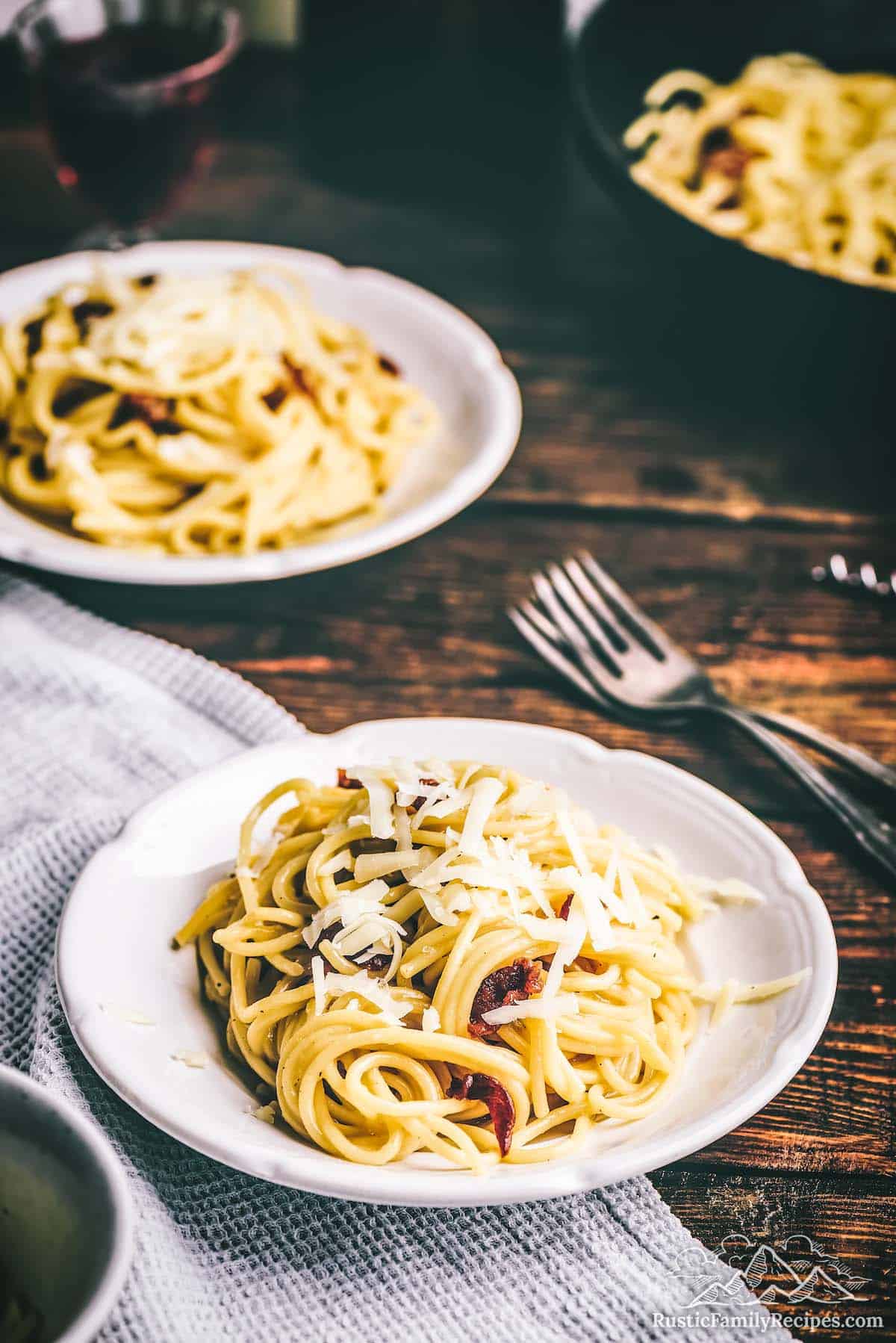 Two white plates with pasta carbonara