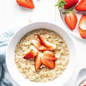 A bowl of steel cut oatmeal topped with strawberries