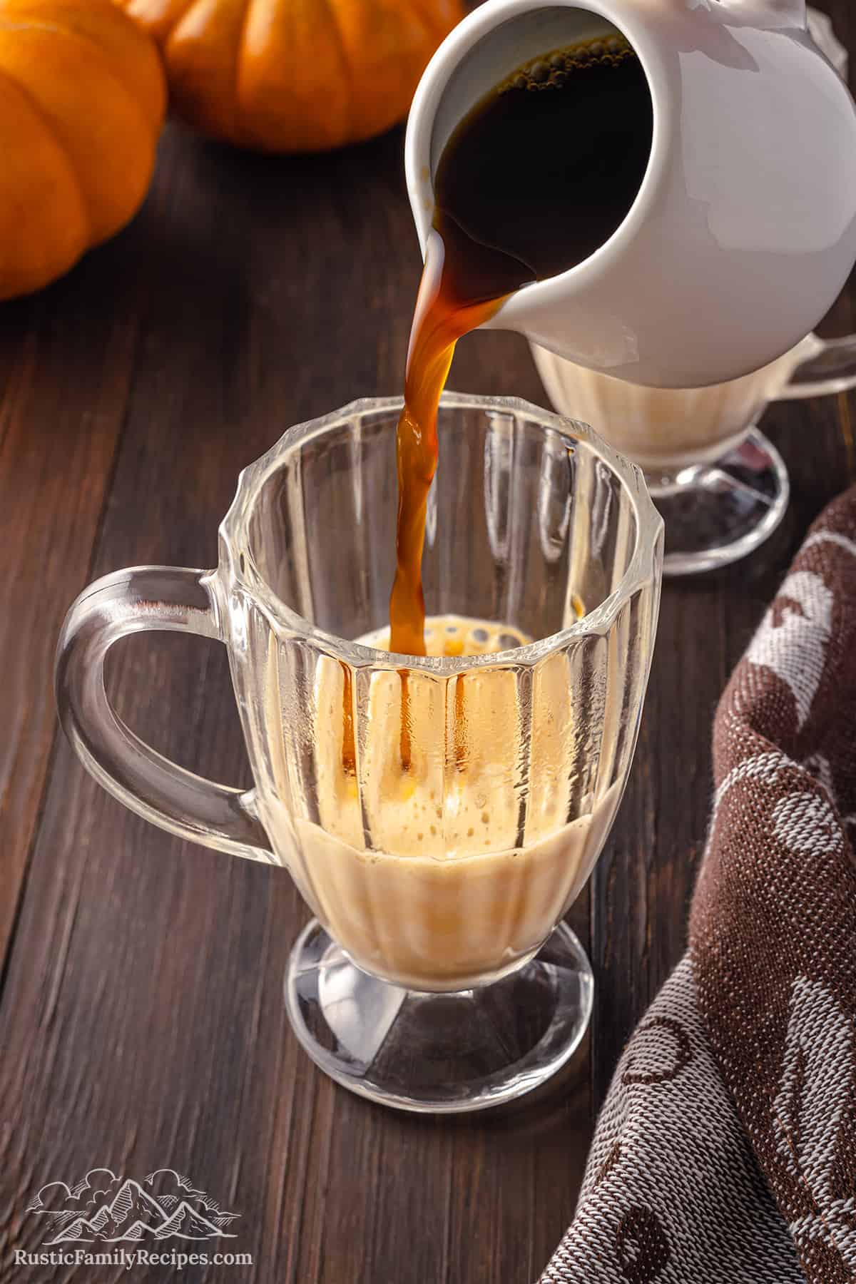 Pouring coffee into a glass with pumpkin milk