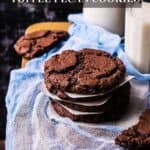 A stack of chocolate cookies next to glasses of milk