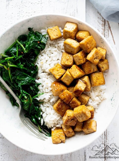 A bowl of maple tofu with sticky rice and spinach