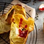 Tall popovers sliced open with butter and jam
