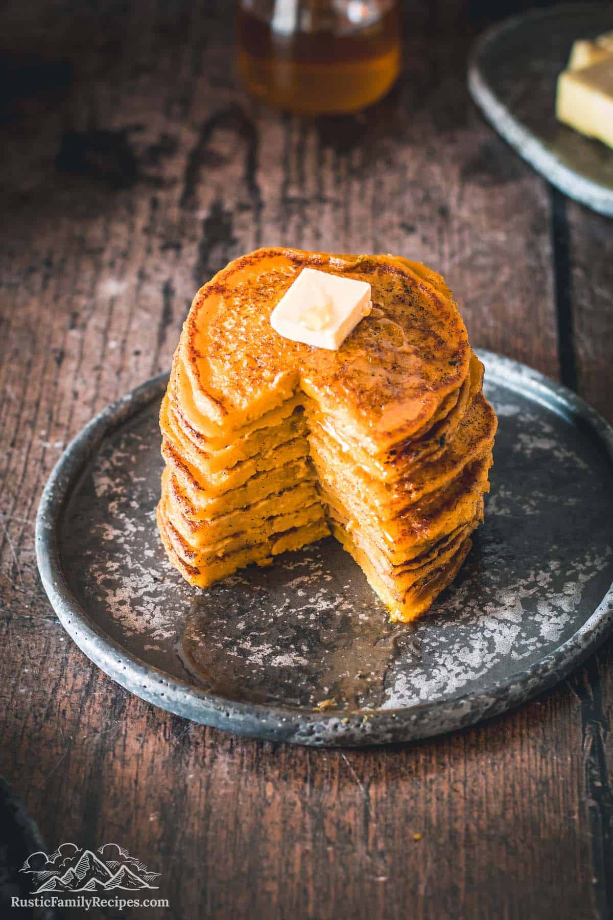 Stack of pumpkin corn cakes with a slice taken out so you can see the inside.