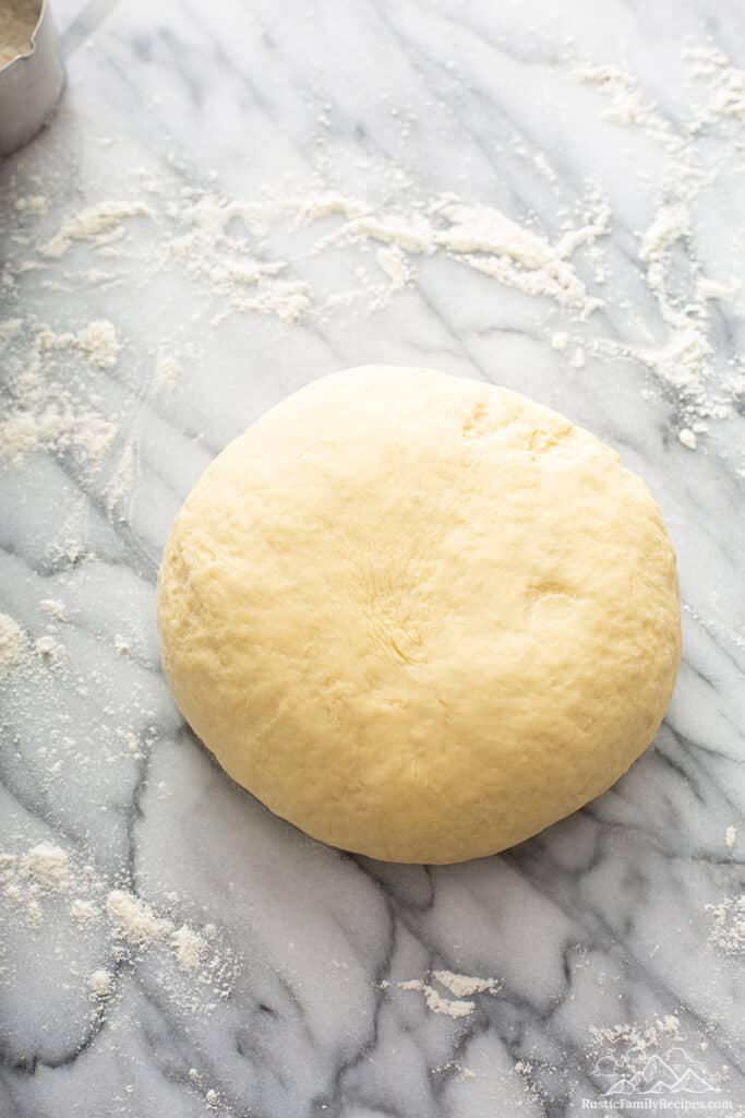Cinnamon bun dough on a marble counter