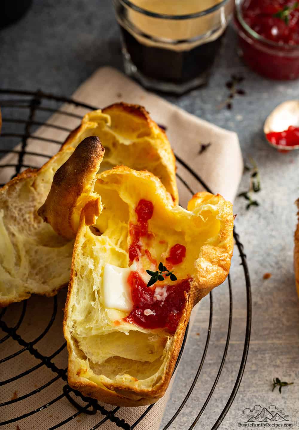 Sliced open popovers with butter and jam. 