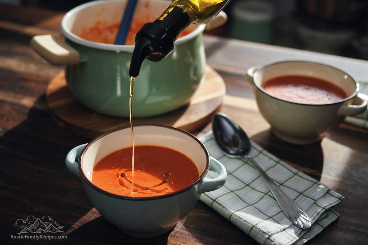 Olive oil poured into tomato soup.