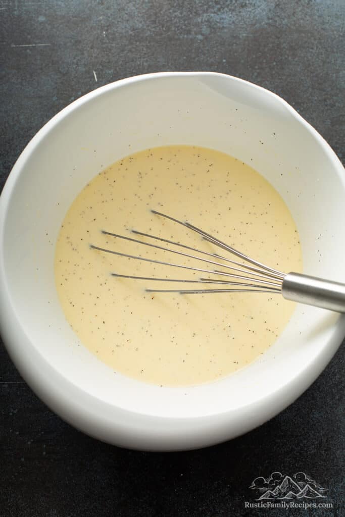 A white bowl with egg custard for strata