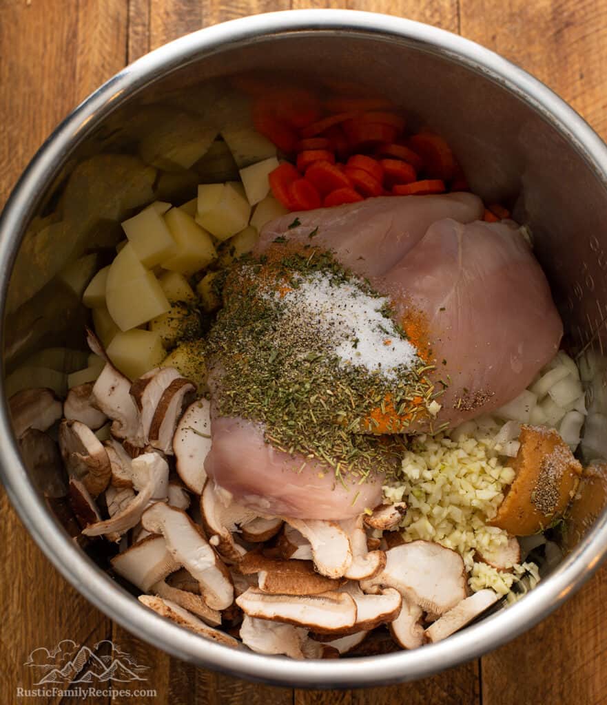 An instant pot bowl filled with chicken soup ingredients.