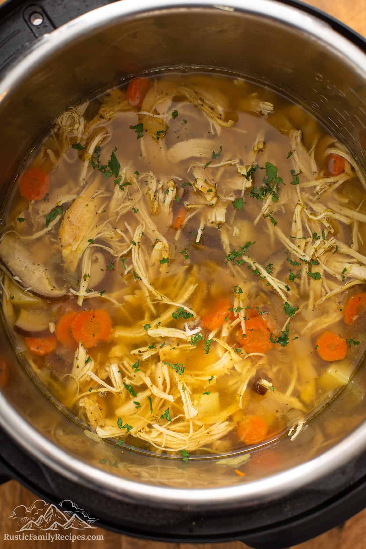 An instant pot bowl with cooked chicken soup