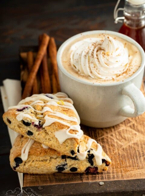 two stacked blueberry scones next to a gingerbread latte