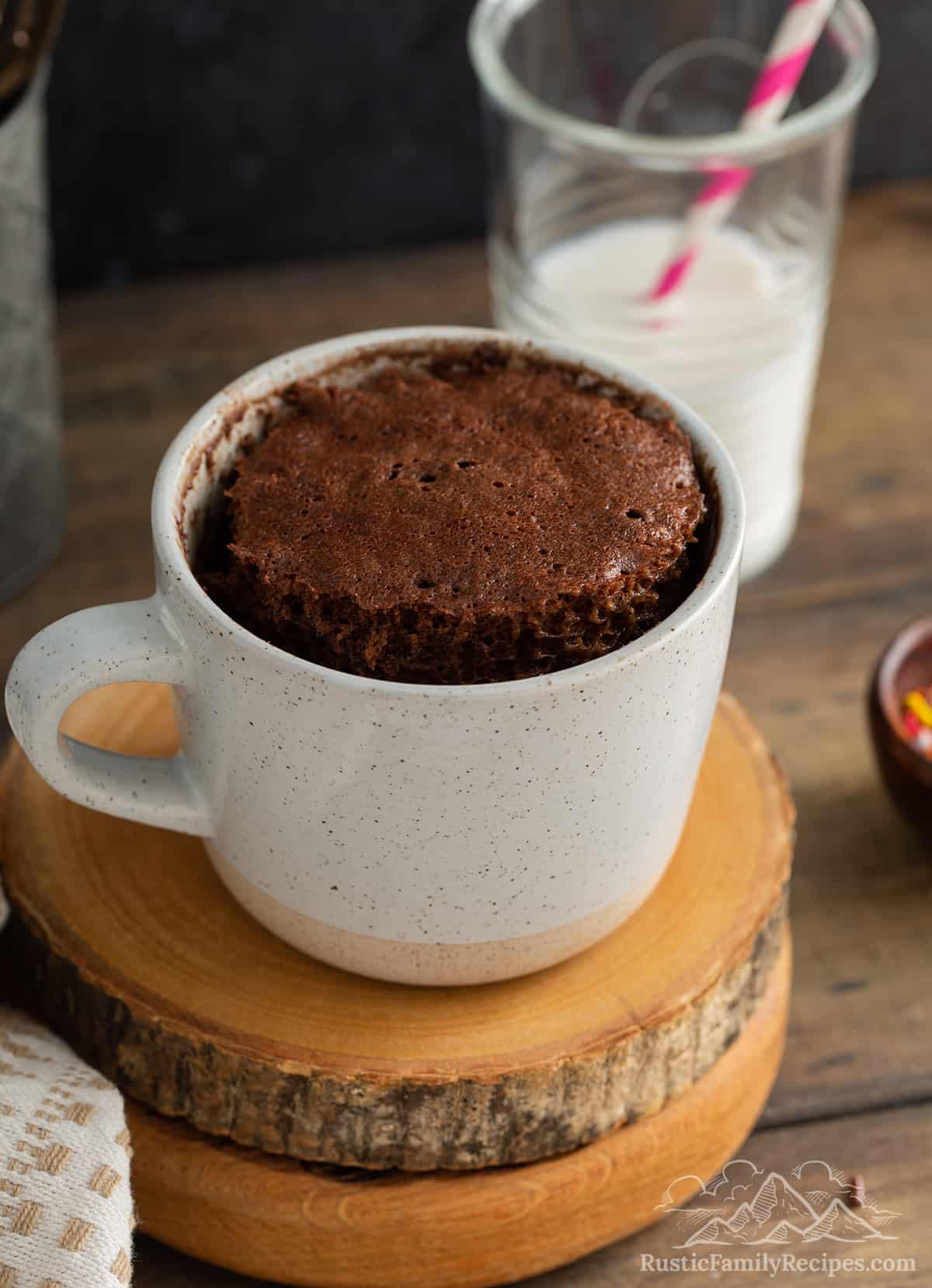 Chocolate cake in a mug on top of wooden slabs