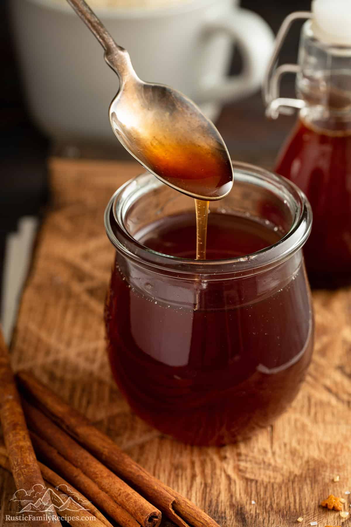 A spoon pouring gingerbread syrup into a jar.