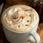 A mug filled with gingerbread latte and topped with whipped cream.