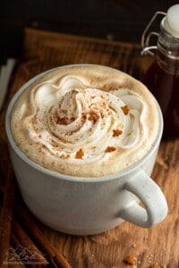 A mug filled with gingerbread latte and topped with whipped cream.