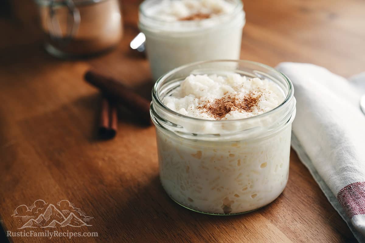 Rice pudding in small mason jars topped with cinnamon.