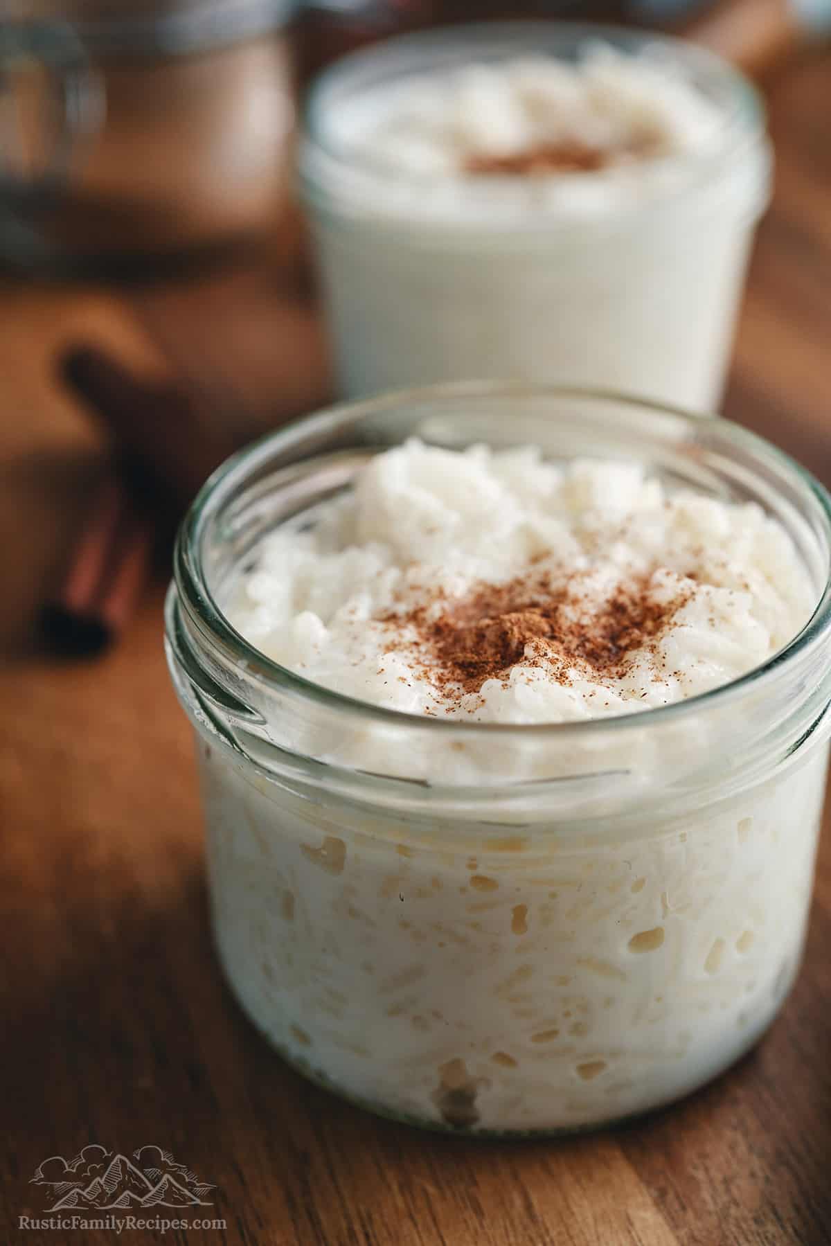 Homemade rice pudding in small mason jars topped with cinnamon.
