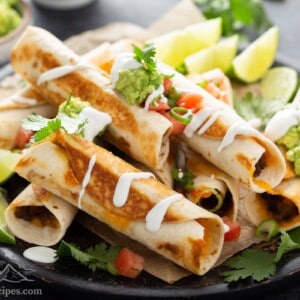 Plate of black bean flautas with lime wedges.