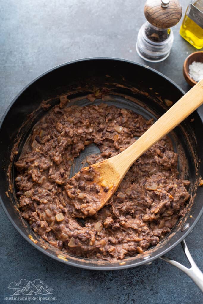 Mashed black beans in a pan.