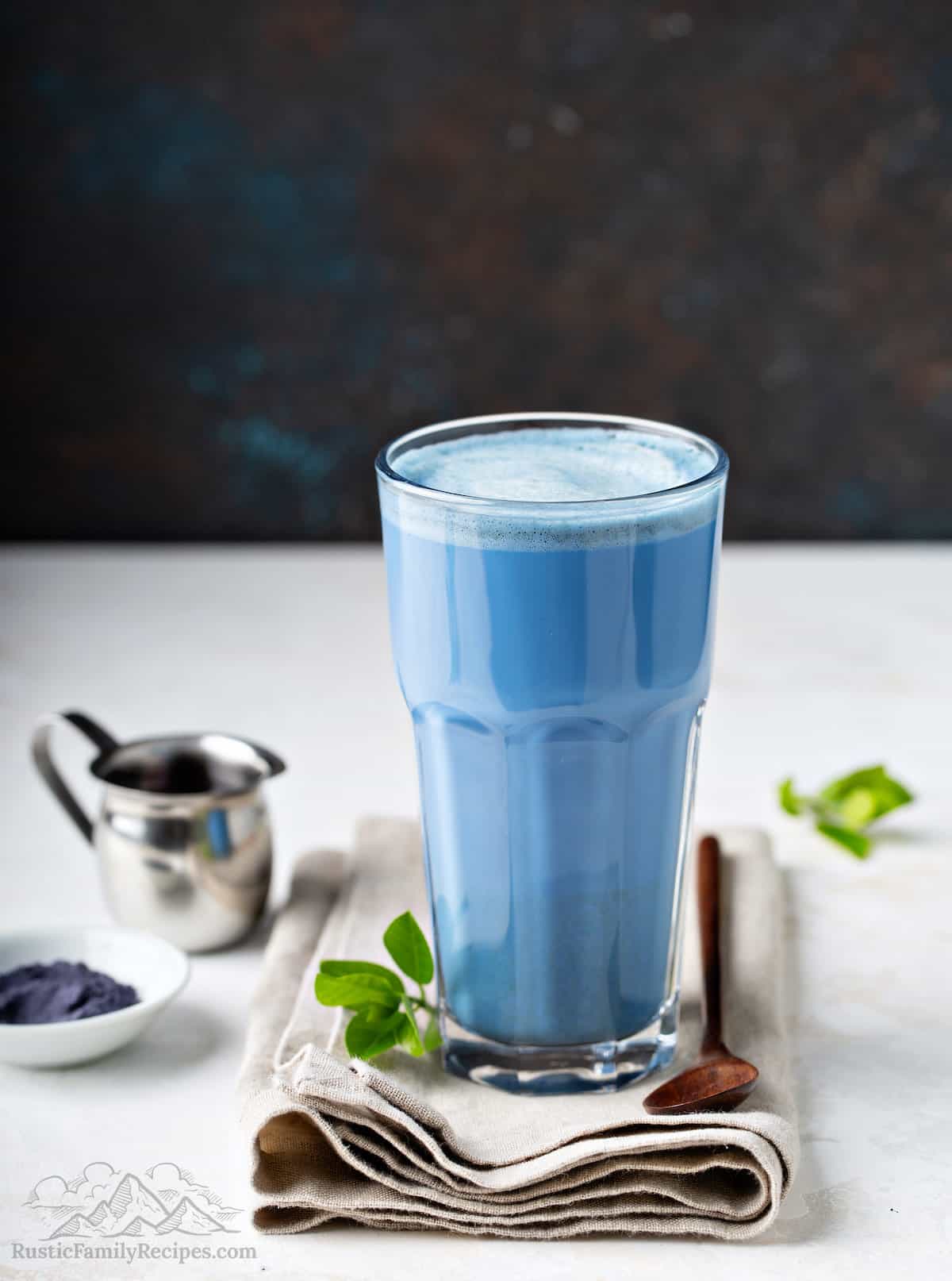 A tall glass with blue matcha latte