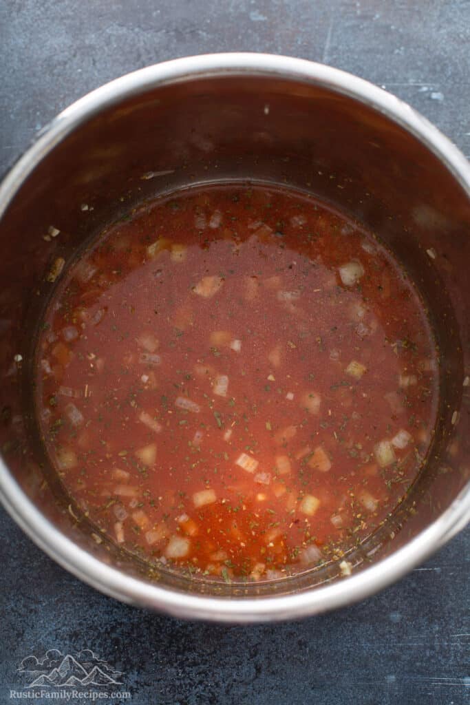 Tomato sauce and vegetable stock in a pot.