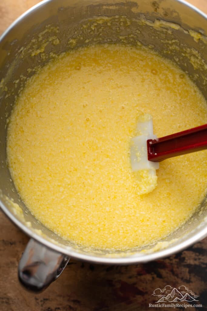 Eggs added to creamed butter and sugar in a mixer bowl.
