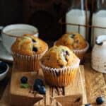 Three sourdough discard blueberry muffins on a wood board