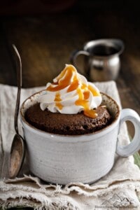 A nutella mug cake in a cup with whipped cream