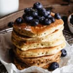 A stack of sourdough pancakes topped with blueberries