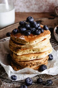 A stack of sourdough pancakes topped with blueberries