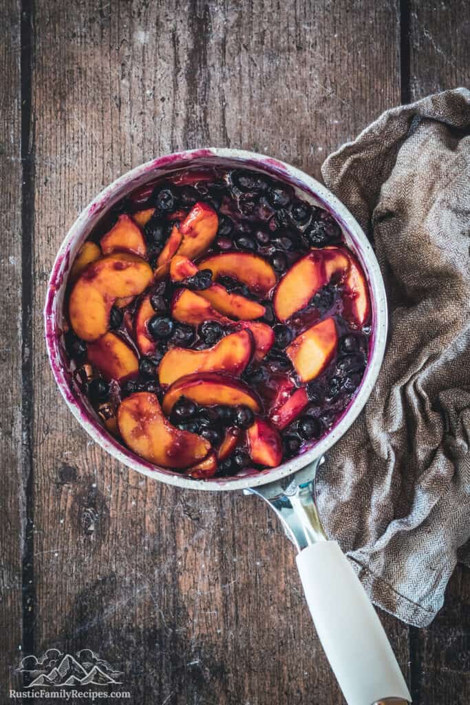 Cooked blueberry peach cobbler filling in a pot