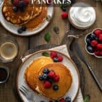 Plates with stacks of pancakes topped with berries