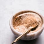 A marble bowl with cinnamon sugar and a spoon