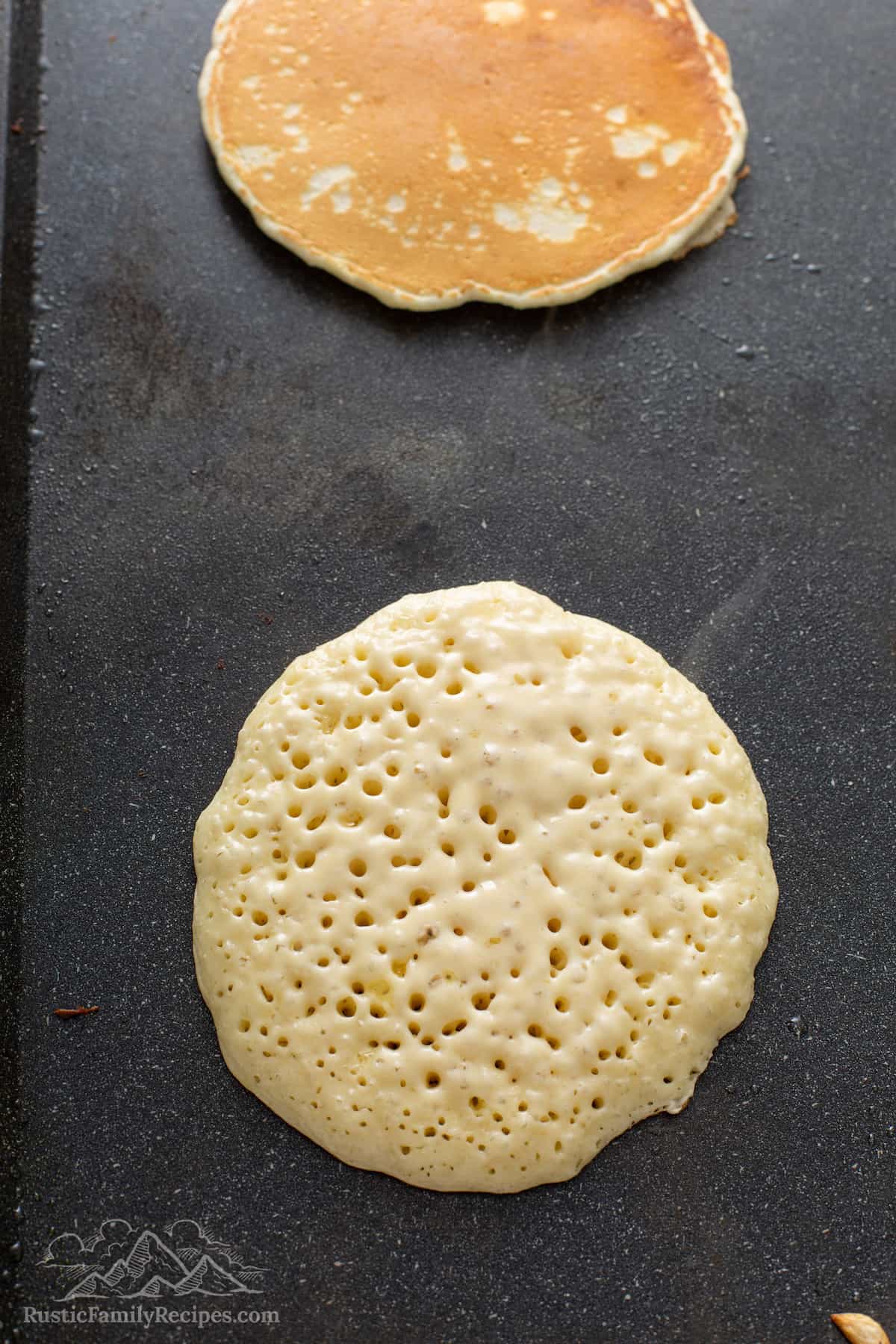 Fluffy pancakes being cooked on a griddle