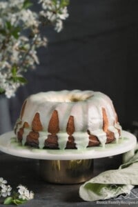 A lemon bundt cake with matcha glaze on a cake stand