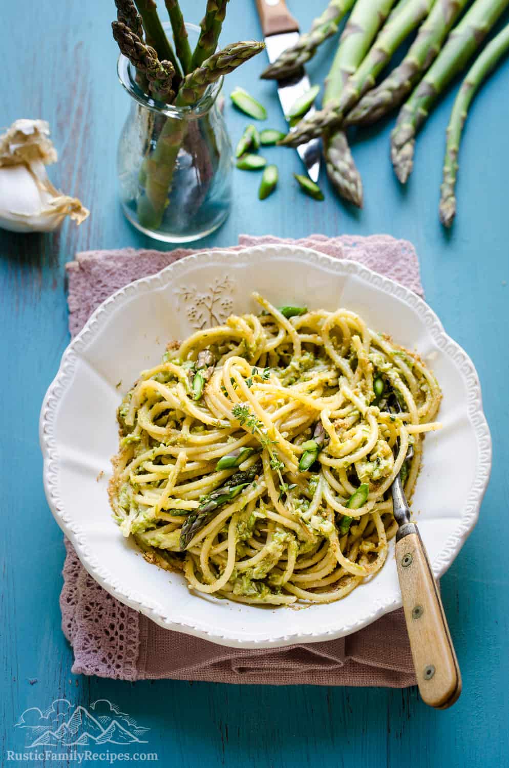 Pasta with pesto alla genovese and asparagus in a white bowl