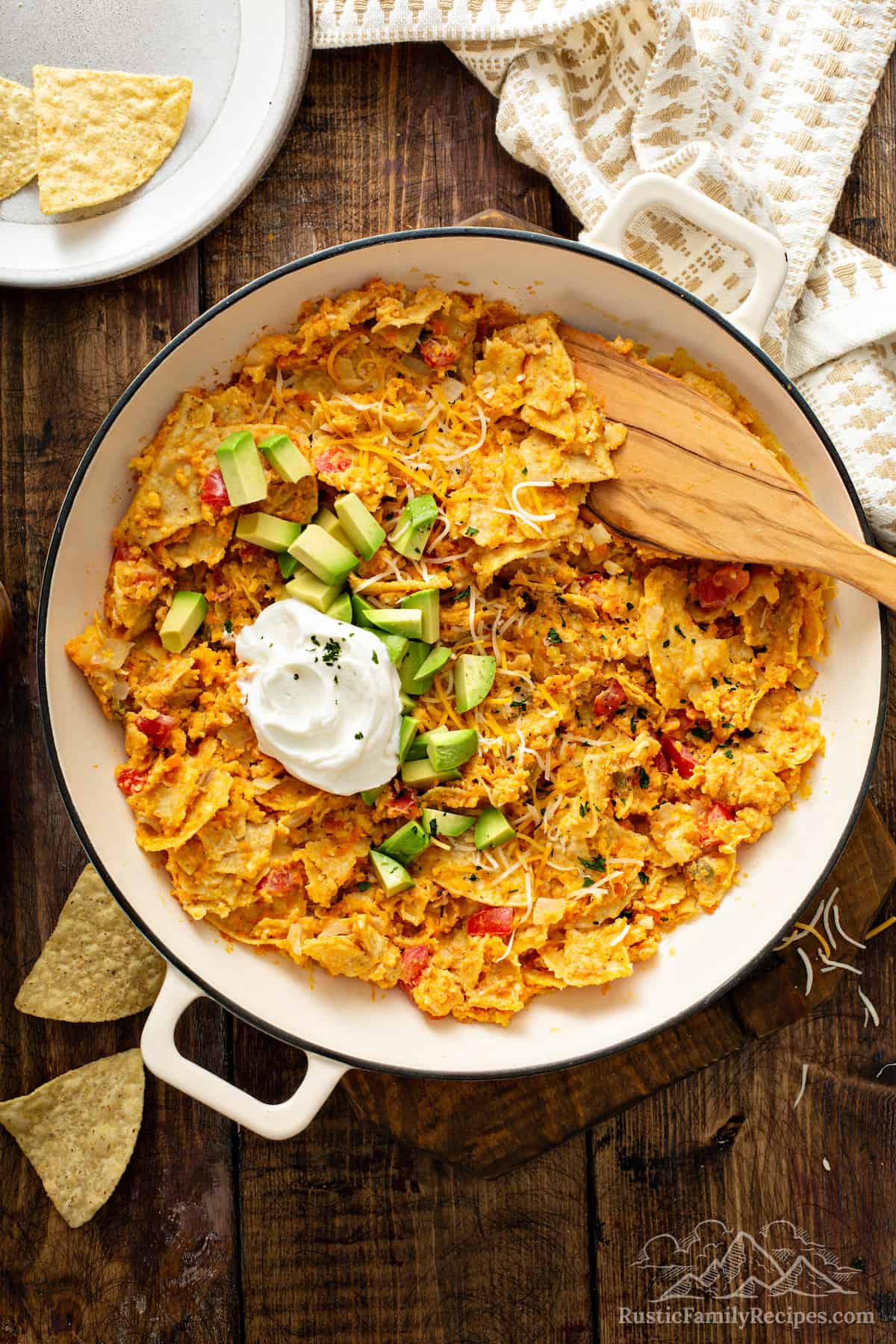 Sweet potato migas in a pan topped with avocado and sour cream