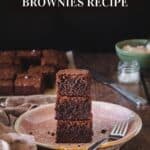 A stack of homemade brownies on a plate with a fork.