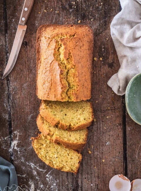 A loaf of Zucchini Cornbread with some slices cut out.