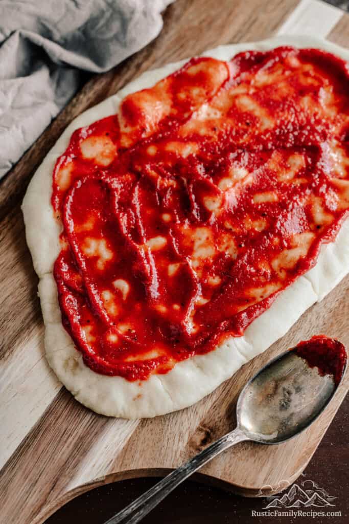 Pizza sauce on uncooked dough