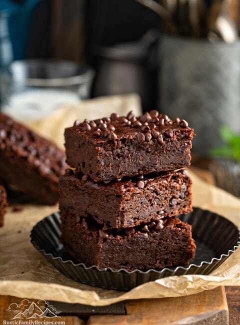 Three vegan sweet potato brownies stacked on a plate