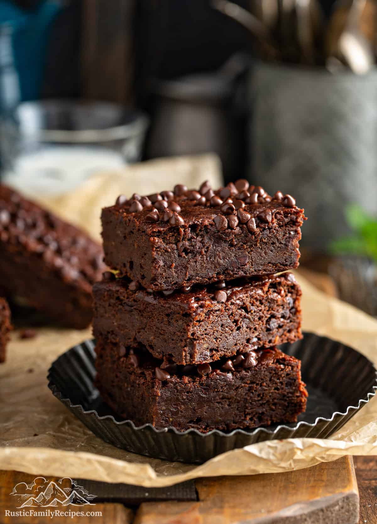 These Pumpkin Sweet Potato Brownies are super good warm with ice cream! The flavor is intensely chocolate, rich and fudgy! Three vegan brownies stacked on a plate