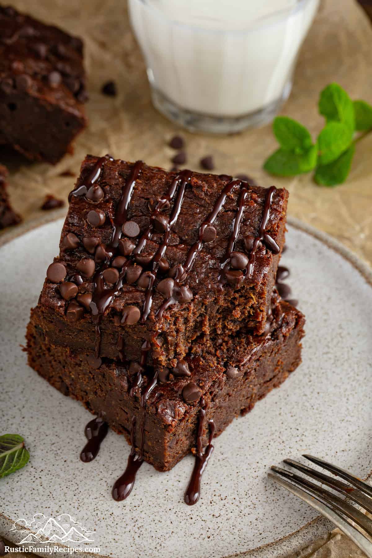 Two sweet potato brownies stacked on a plate