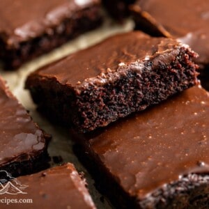 A stack of zucchini brownies on parchment paper